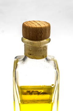 semi-filled瓶与黄色的液体和软木塞塞前面白色背景