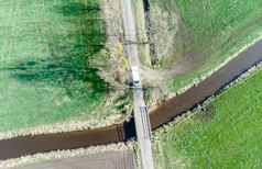 空中视图流流动通过梅多斯和字段下小桥使与无人机