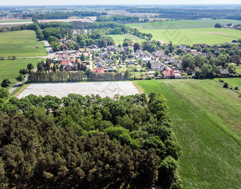 空中视图小村的距离后面一块森林和芦笋场覆盖与箔使与无人机