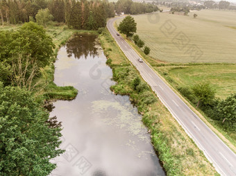 空中视图小池塘平行国家路Saxony-Anhalt与字段和森林的周围区域使与<strong>无人机</strong>