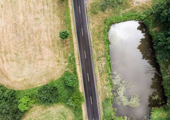 空中视图小池塘平行国家路Saxony-Anhalt与字段和森林的周围区域使与无人机
