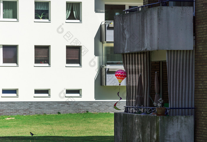 阴暗的黑暗结算与梯田房子郊区与明亮的色彩斑斓的玩具气球丑陋的脏老阳台郊区