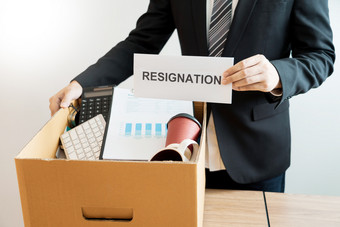 商人携带包装个人公司棕色（的）纸板盒子和辞职信为辞职改变工作离开的办公室失业辞职概念