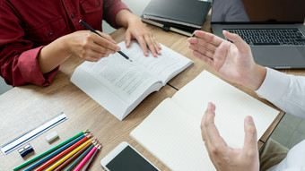 教学帮助技术概念女人年轻的老师导师与成人学生教室桌子上与论文移动PC电脑研究课程