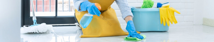 管家女仆穿橡胶手套与布清洁应用地板上哪和