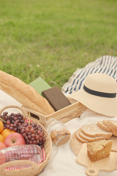 野餐概念野餐餐的白色布组成篮子水瓶苹果橙子和葡萄面包面包Jar饼干和片面包