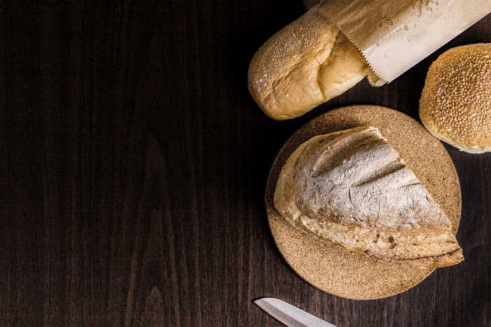 面包概念一半面包面包的木板面包面包成纸袋刀和好把黑色的木场景