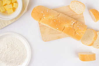 面包概念面包面包几片面包木切割董事会和碗黄油说谎的白色场景