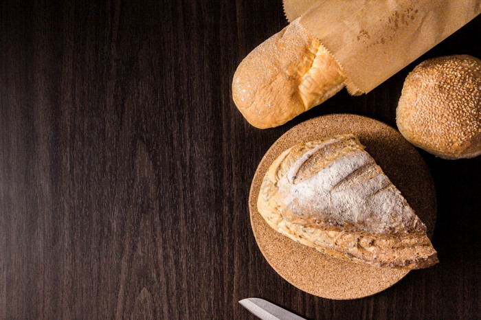 面包概念一半面包面包的木板面包面包成纸袋刀和好把黑色的木场景
