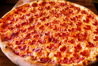 热大意大利辣香肠披萨美味的披萨作文与融化奶酪培根西红柿他红辣椒蒸汽烟黑色的背景