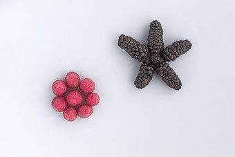 成熟的浆果树莓和大黑色的黑莓是位于对角光背景的图像高关键树莓和大黑色的黑莓是安排对角光背景