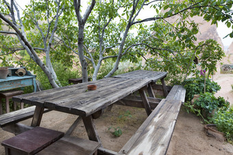 老餐厅饱经风霜的木表格和长椅的花园下的杏仁树等待为它的主人老饱经风霜的木表格和长椅的花园下的树