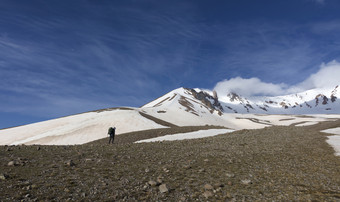 女人旅游与背包去徒步旅行雪山的旅游上升的山腰的白雪覆盖的峰会