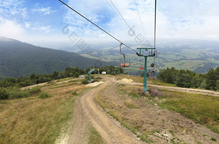 的山电梯携带游客和行李和下来的山对的背景的夏天山风景的喀尔巴阡山的山电梯携带游客和行李和下来的山