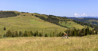 骑摩托车的人喀尔巴阡山脉的山脉极端的体育运动活跃的生活方式冒险巡回演出概念骑摩托车的人移动下来的坡的喀尔巴阡山脉的山
