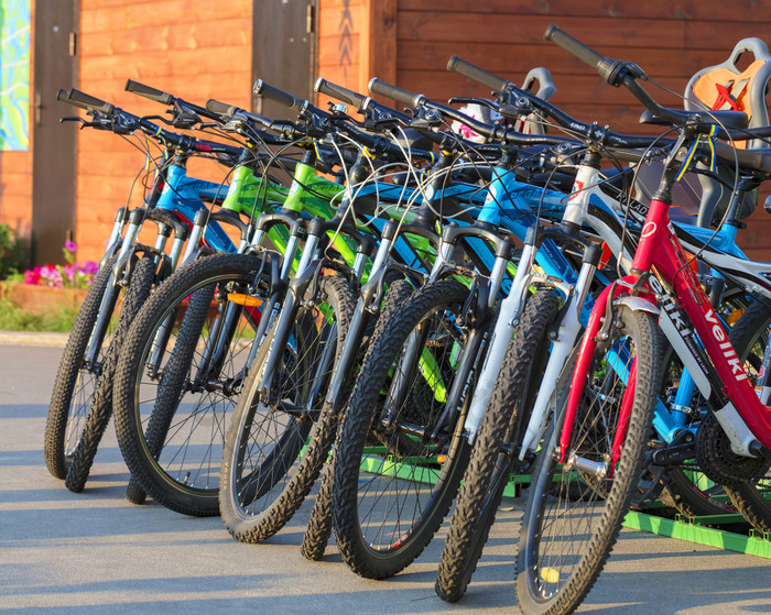 集团色彩斑斓的自行车停车很多站在一起的沥青的公园在的明亮的射线的设置太阳集团色彩斑斓的自行车停在一起停车很多特写镜头
