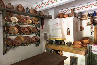 陶瓷画碗盘子和壶木架子上的墙老烤箱与玻璃器皿的室内的古老的乌克兰农村房子设计老烤箱和厨房货老乌克兰农舍