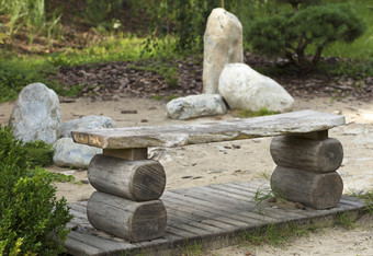 老木板凳上绿色灌木盆景树日本岩石花园木板凳上的日本花园石头