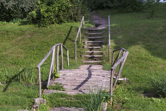 老日志木桥在流与木步骤扶手和污垢路径领先的山老日志木桥在的流