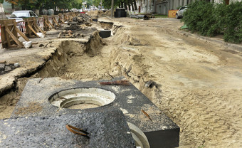 混凝土块井和管道的城市收集器谎言附近的挖掘沟的巷道的街修复的城市下水道的巷道的街