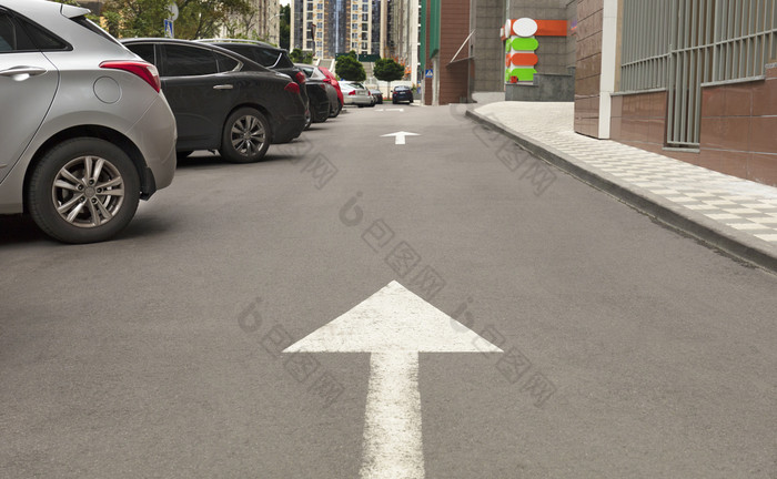 路标记箭头的沥青表明的方向为开车车辆附近的当地的区域的箭头的沥青表明的方向为的运动汽车