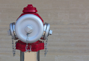 的头的火红色的消火栓与磨砂钢帽的背景的花岗岩墙特写镜头新和现代钢火消火栓特写镜头