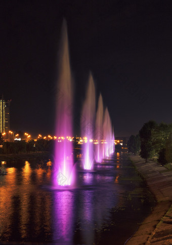 美丽的明亮的和高喷泉的rusanovskaya通道的Dnipro路堤的城市景观的晚上基辅美丽的明亮的和高喷泉的rusanovskiy通道的晚上基辅