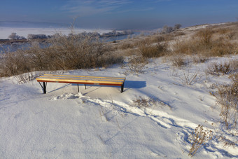 视图木板凳上站高银行的河明亮的冬天一天农村冬天景观冬天景观阳光明媚的一天的足迹的新鲜的雪引领木板凳上那站的高银行的河