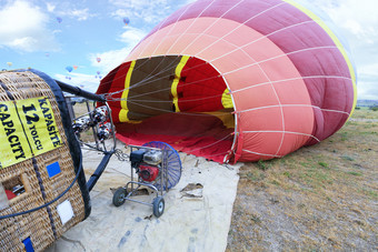 人膨胀气球与气体火炬和<strong>大容量</strong>汽油工业风扇倾斜的运输篮子的一边的过程膨胀气球与汽油风扇和气体燃烧器