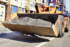 重建设推土机携带老穿沥青包在的建设路城市街中午重建设推土机携带的桶的老沥青在的修复的车道