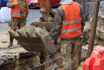 桶重建设挖掘机包围路工人电梯沙子在下水道修复城市街桶重建设挖掘机包围路工人挖掘沟当修复城市下水道的巷道