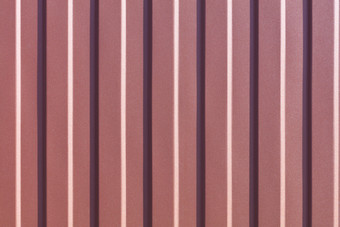 棕色（的）金属栅栏使波纹钢表与垂直指南波纹棕色（的）铁表背景关闭棕色（的）波纹钢表与垂直指南