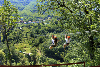 女孩的电缆车是发送通过的山和的森林通过的谷的河头饰黑山共和国游客交叉的长路径通过的山和森林在的河头饰电缆车
