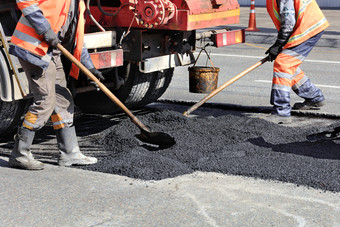 的路工人rsquo工作集团更新部分的路与新鲜的沥青和水平为修复路建设的工作团队更新部分沥青与铲子路建设