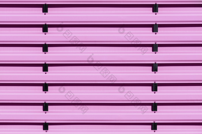 粉红色的站金属栅栏使钢木板与垂直黑色的指南铁栅栏画粉红色的颜色背景特写镜头粉红色的金属保护栅栏与垂直指南