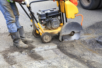 的路技术员开始的引擎汽油钻石看到删除老沥青在维修的巷道的工人开始的引擎的汽油刀减少和清晰的坏沥青的巷道
