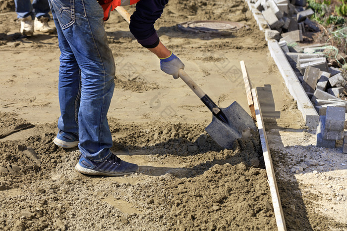 的工人对齐的基金会与沙子和铲下的木水平为铺设铺平道路板的背景的网站准备为工作工人使用铲配音沙子木水平水平的基金会