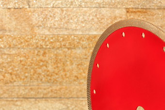 钻石红色的切割段对金砂岩墙特写镜头复制空间为文本片段红色的钻石叶片为切割花岗岩转向的墙金砂岩