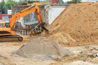 重履带建设挖掘机加载沙子建设网站在路修复城市街夏天一天图像与复制空间重建设挖掘机在的建设路和新多层建筑