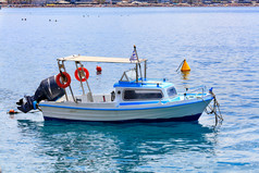 小救援船与强大的电动机和橙色救生圈董事会摇摆的海波的希腊海岸对的背景的海滩海岸线图像与复制空间视图小救援船与强大的电动机的背景的海滩海岸线