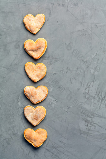 美味的自制的姜饼酥饼饼干的形状见不得人的心铺设出垂直行灰色的混凝土表面图像与复制空间美味的自制的姜酥饼姜饼饼干灰色的混凝土表面
