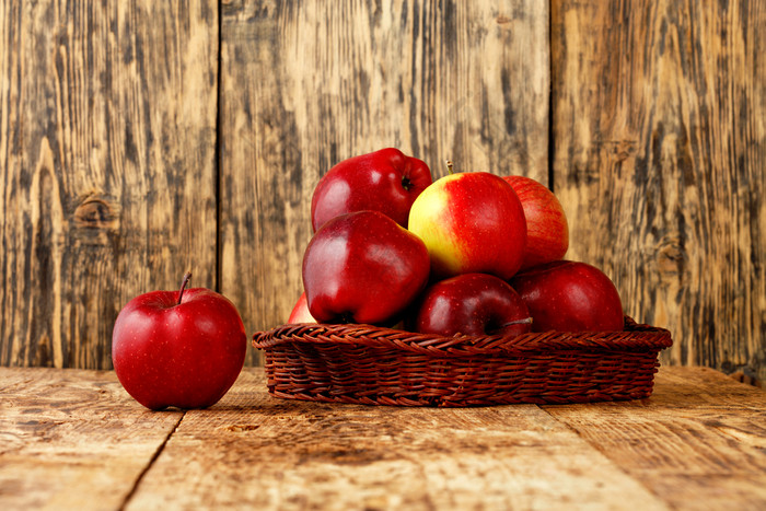 红色的成熟的苹果谎言柳条篮子老木表格木背景图像与复制空间红色的成熟的苹果谎言柳条篮子老木表格