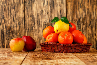 新鲜的柑橘类水果橘子和柠檬与绿色叶子柳条篮子红色的成熟的苹果谎言老木表格木背景图像与复制空间橘子和柠檬柳条篮子红色的苹果谎言老木表格