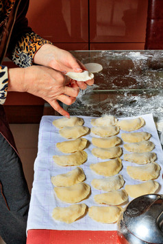 的家庭主妇煮熟的生饺子和铺设他们布为后续烹饪乌克兰国家厨房特写镜头女人传播的完成了生饺子组织餐巾