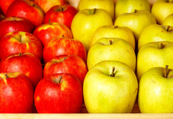 明亮的背景新鲜的苹果红色的和黄色的那是铺设出甚至行市场计数器和吸引了注意焦点前景背景轻微的模糊多汁的苹果背景从红色的和黄色的苹果为出售的市场特写镜头