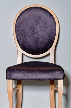 经典木椅子与软黑暗紫色的室内装潢和轮回来拍摄前面灰色的讲台上和背景木椅子与软鞍和轮回来灰色的讲台上和背景