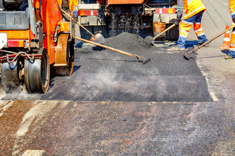 团队路工人保护橙色工作服维修部分的路使用铲子水平和小路设备复制空间团队路工人维修部分的路使用手工具和路设备