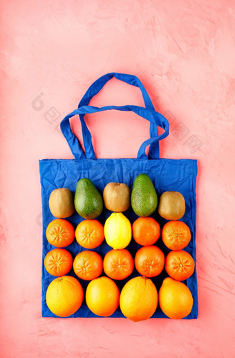 零浪费概念环保袋使经典蓝色的棉花粉红色的背景塑料环保商店与水果和蔬菜平躺复制空间零食物购买环境友好的袋与水果和蔬菜粉红色的背景
