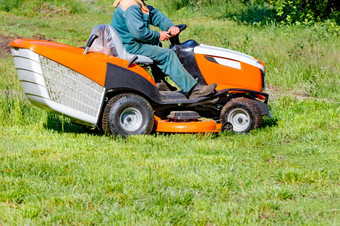 服务工人割草的草坪上与专业草坪上割草机清晰的阳光明媚的一天复制空间服务工人割草与拖拉机草坪上割草机