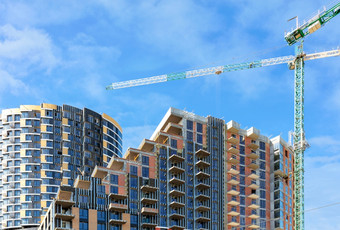 monolithic-frame级联混凝土结构和塔起重机的建设网站多层住宅建筑对背景蓝色的天空和白色云复制空间建设网站多层住宅复杂的与级联地板对蓝色的多云的天空复制空间